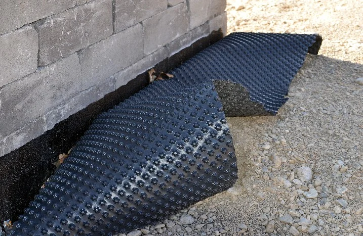 Schwarze Noppenbahn an Kellerwand